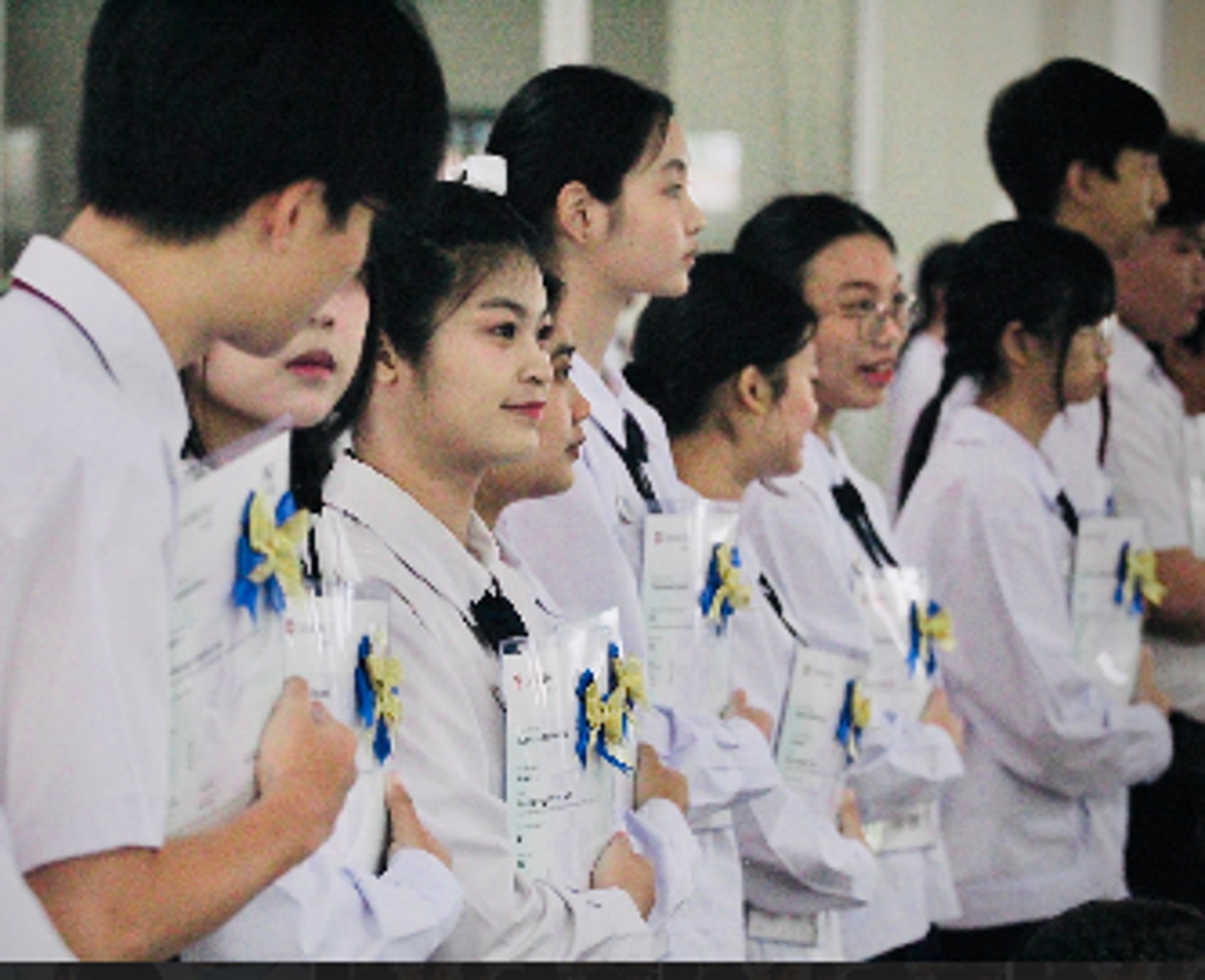 นักเรียนถือเกียรติบัตร Cambridge English เข้าแถวรับมอบ